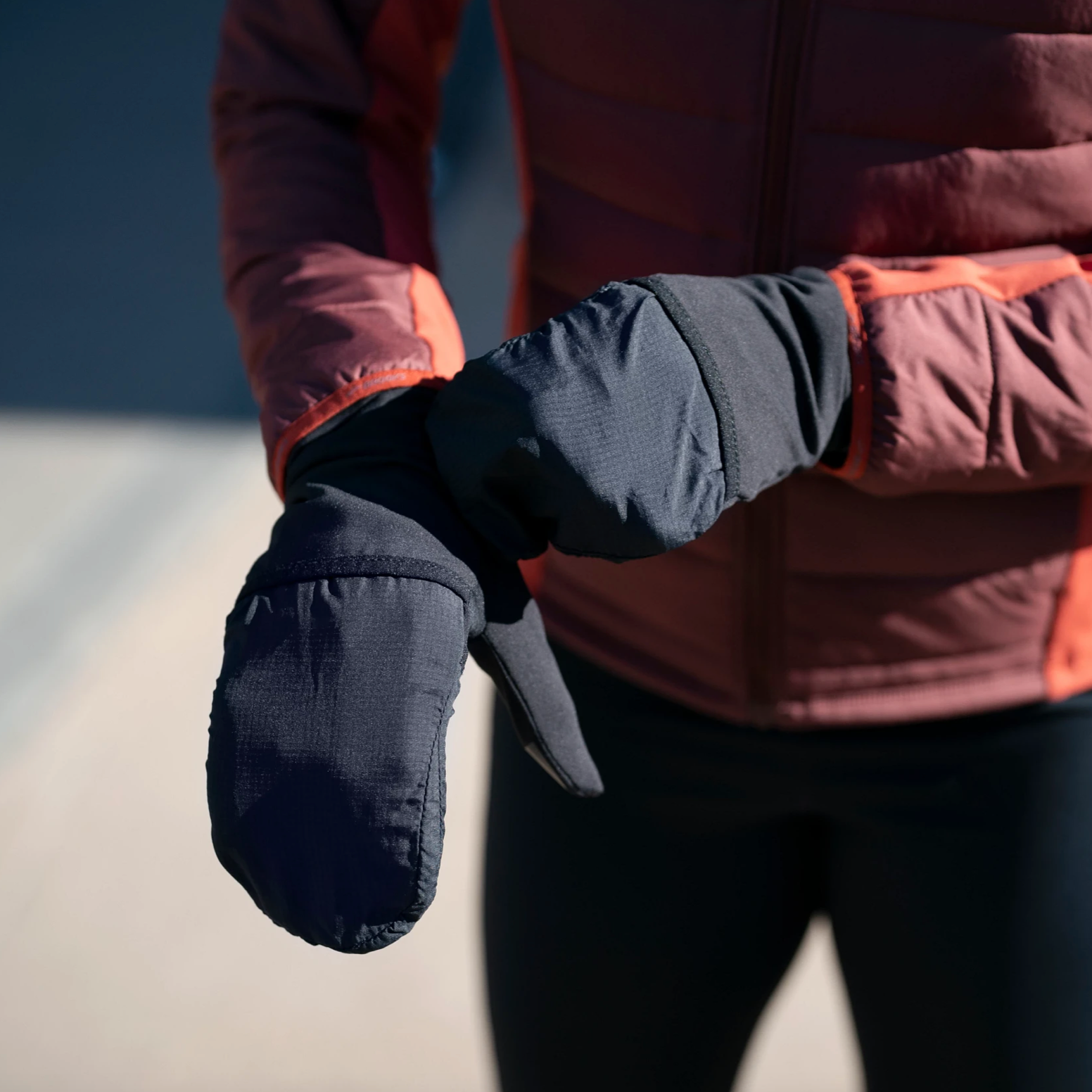 picture of someone putting on gloves. click to shop winter glove and headwear.