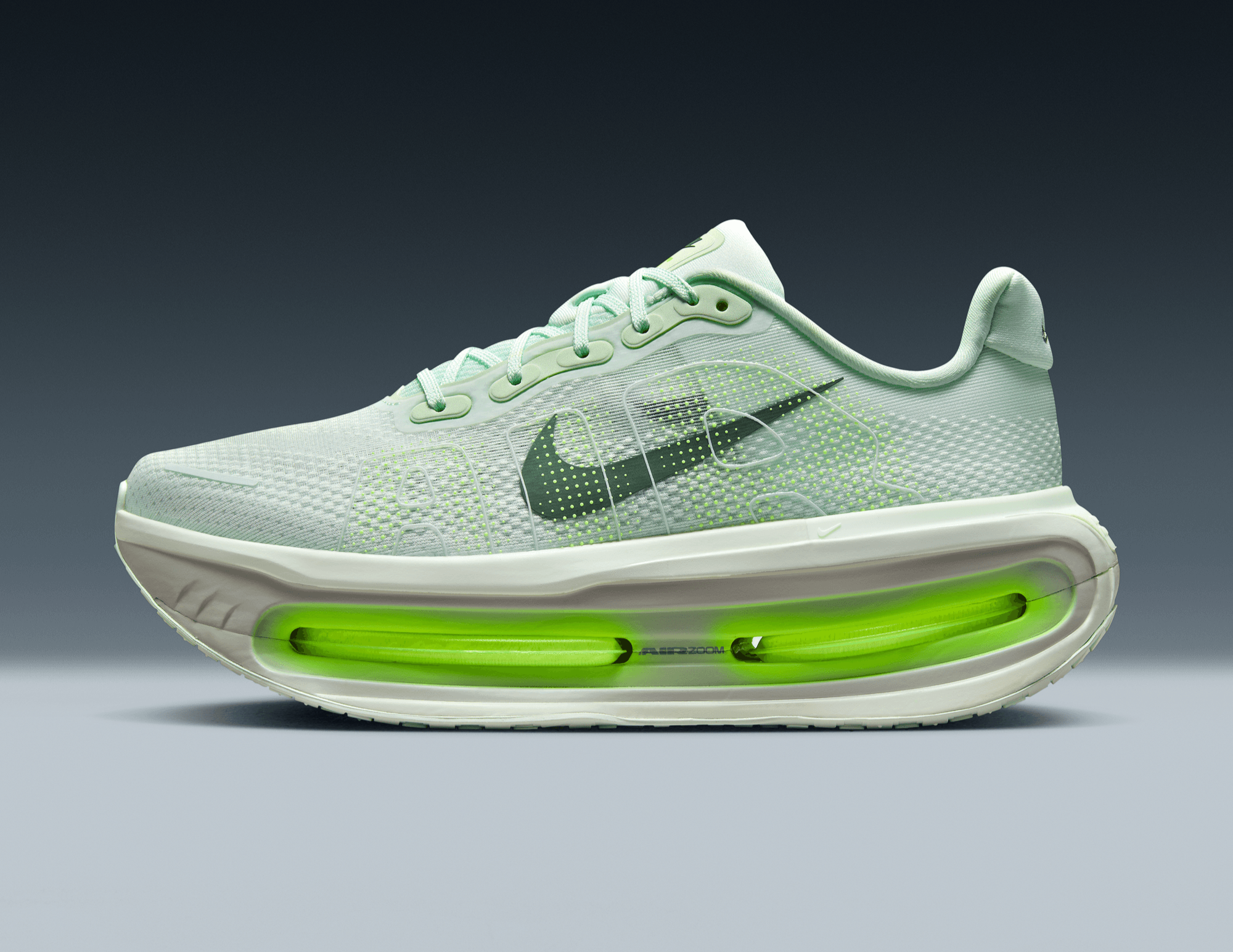 Light blue running shoe with green sole on a gray background
