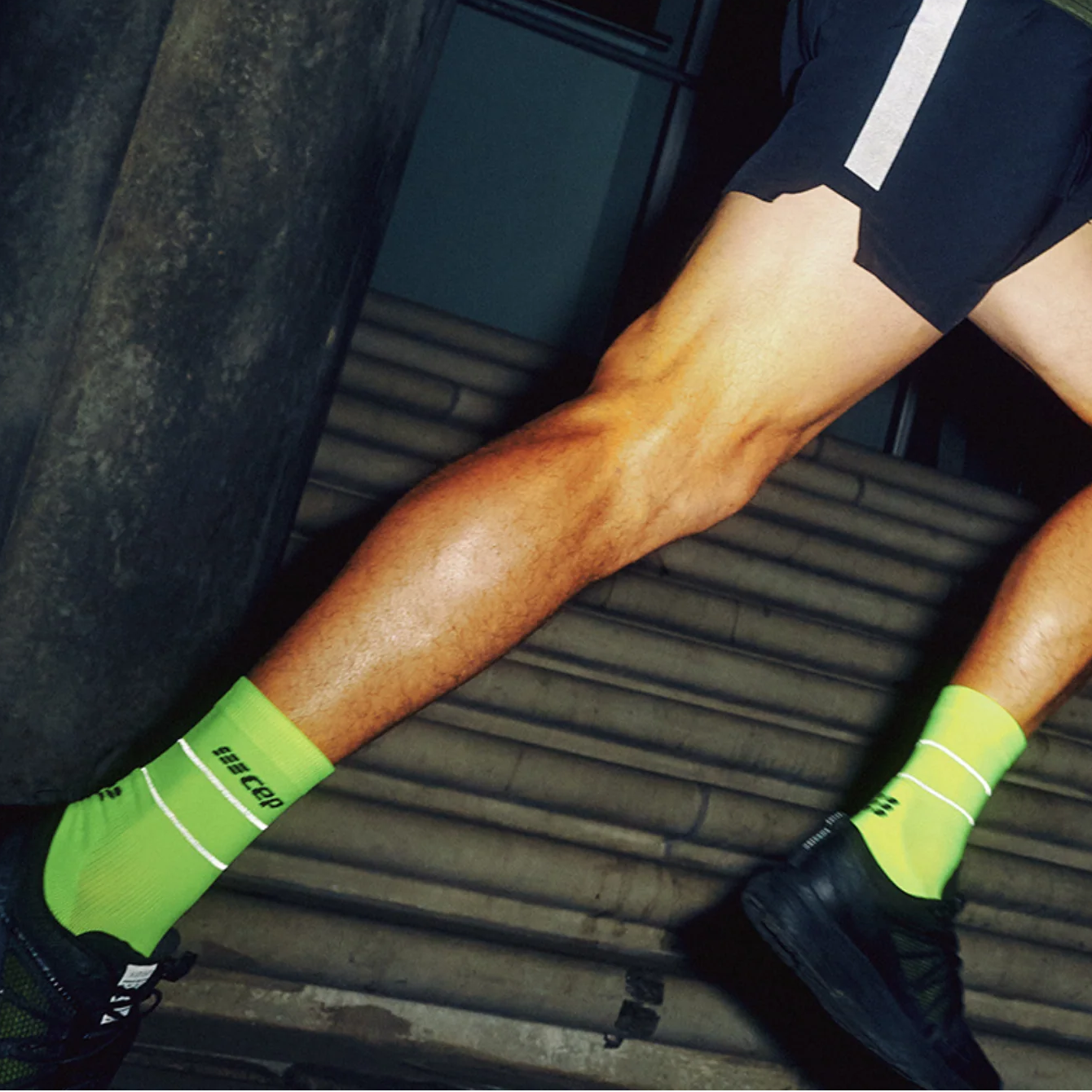 Person wearing a green athletic outfit with lightning patterns, black shorts, and green socks with white stripes.